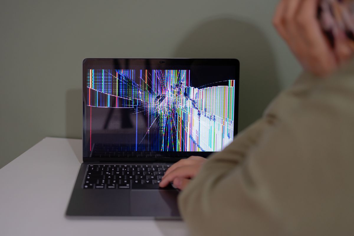 Laptop with a broken display being inspected